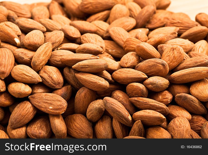 Close crop of a pile of shelled almonds with sharp detail in front and gradually blurring towards the back