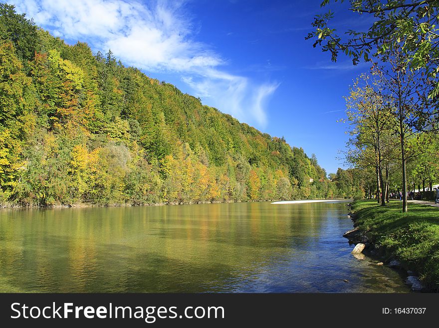 River in autumn with colorful trees and blue sky