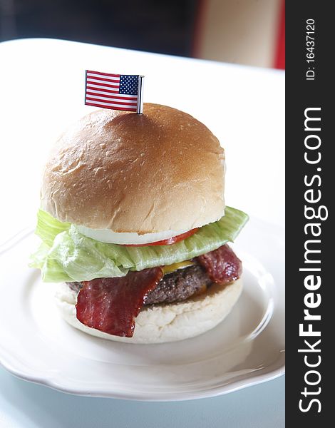 Cheese bacon beef burger with lettuce on the dish. Cheese bacon beef burger with lettuce on the dish.