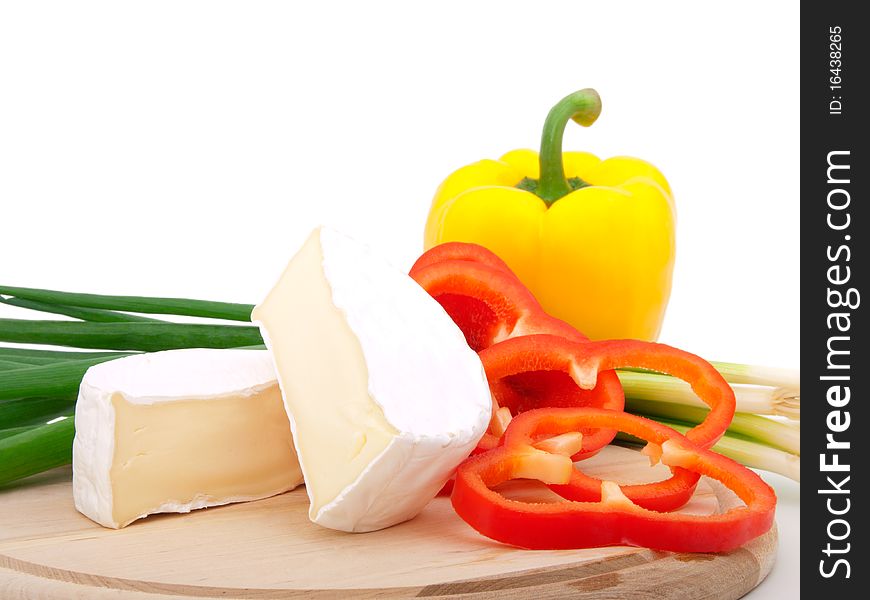 Wheel of French cheese with vegetables (onion, paprika), on white background