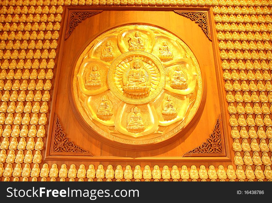 Golden buddha on wooden wall