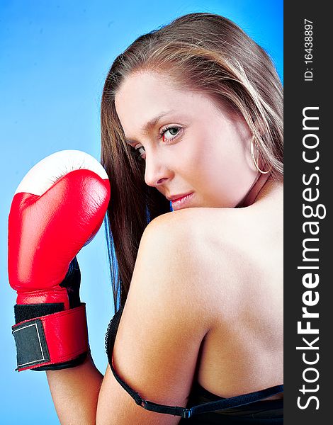 Female fighter boxer on the light blue background
