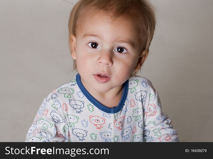 Portrait of a beautiful little boy with big eyes in a sleepwear