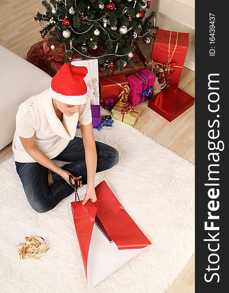 Blond woman sitting on the floor with a christmas gift