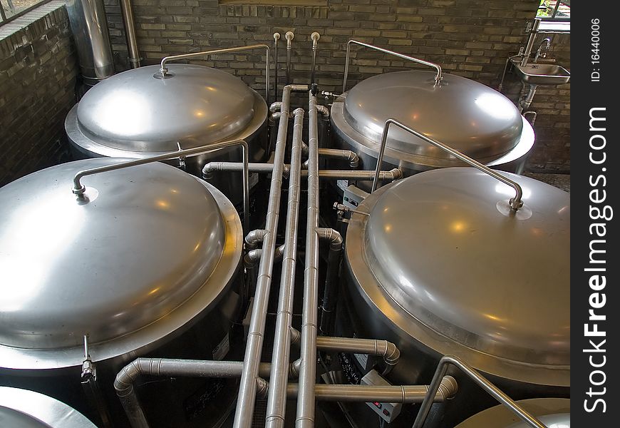 Traditional style brewery brew house inside a restaurant with metal tanks. Traditional style brewery brew house inside a restaurant with metal tanks