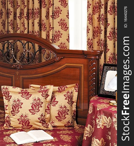 Red bedroom; wooden bed with pillow