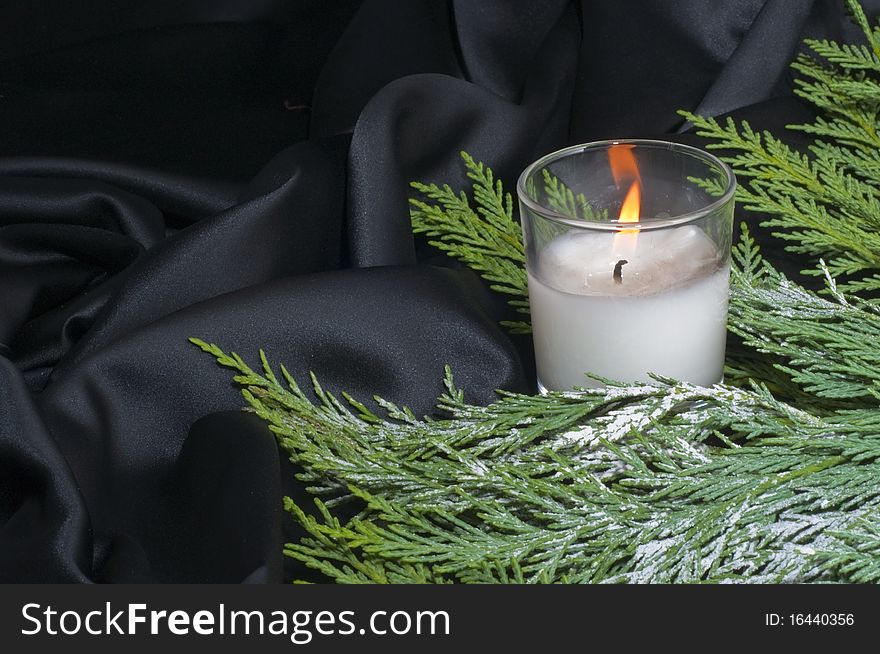 Christmas composition with candle lit on a black background. Christmas composition with candle lit on a black background