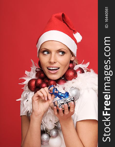 Beautiful young female nikolaus with some christmas balls and a present. Beautiful young female nikolaus with some christmas balls and a present