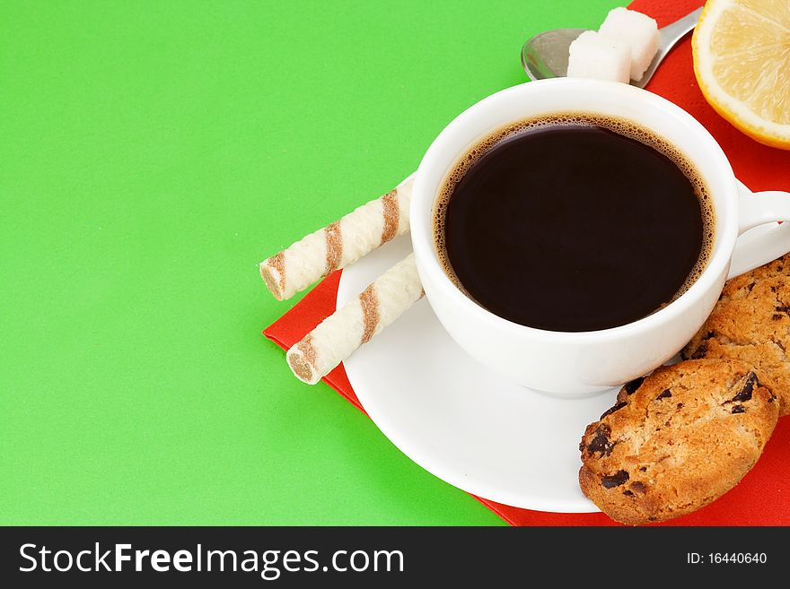 Coffee, waffle and cookies on green background