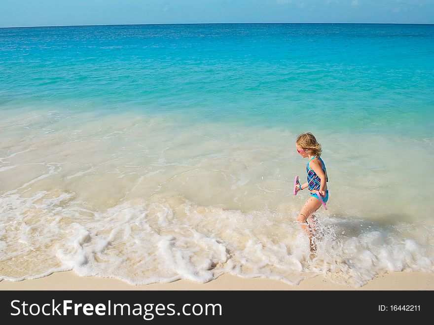 :little girl running on the waves in carribian ocean in nice summer day. :little girl running on the waves in carribian ocean in nice summer day.