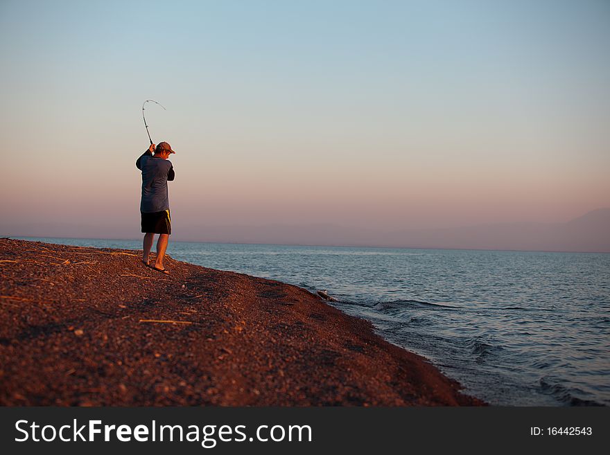 The fisherman fishes on a sunset