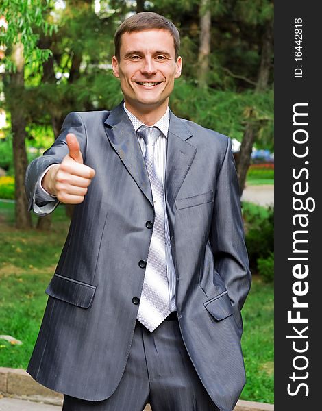 Portrait of young businessman with thumb up