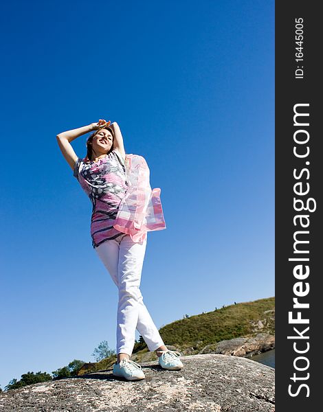 Positive young girl against the sky in summer