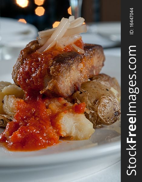 Grilled sweetbreads over potatoes with red sauce