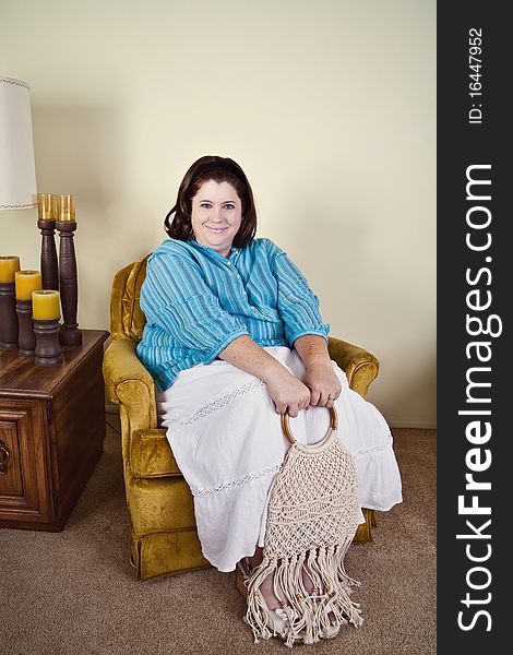 Woman in her early 40's sitting in a 1970's style home, wearing 1970's style clothing and macrame purse. Woman in her early 40's sitting in a 1970's style home, wearing 1970's style clothing and macrame purse.