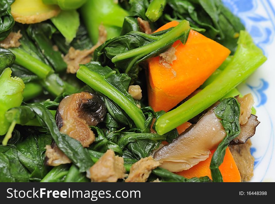 Sumptuous Chinese vegetarian cuisine. Ingredients include green, leafy vegetables, mushrooms, carrots, and slices of ginger. Sumptuous Chinese vegetarian cuisine. Ingredients include green, leafy vegetables, mushrooms, carrots, and slices of ginger.