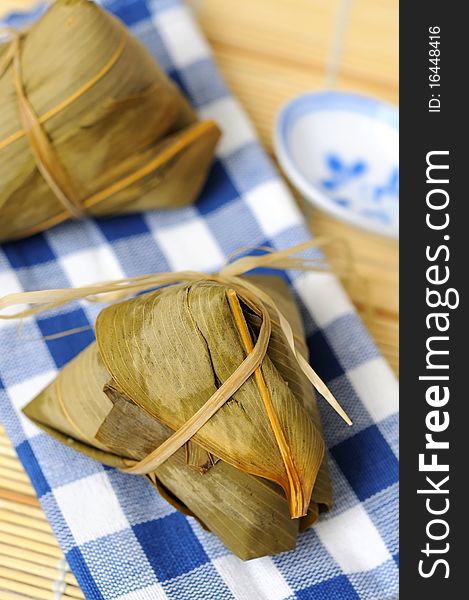 Two rice dumplings wrapped in traditional bamboo leaves.