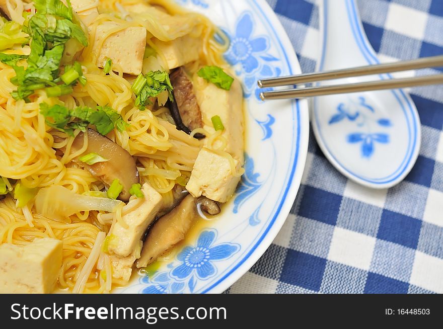 Asian style vegetarian noodles topped with healthy vegetables and mushrooms.