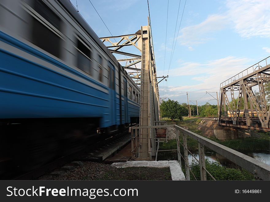 A passenger train ride over a bridge. A passenger train ride over a bridge