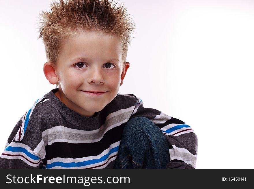 Cute little boy smiling at the viewer and wearing stripes on a white background. Cute little boy smiling at the viewer and wearing stripes on a white background