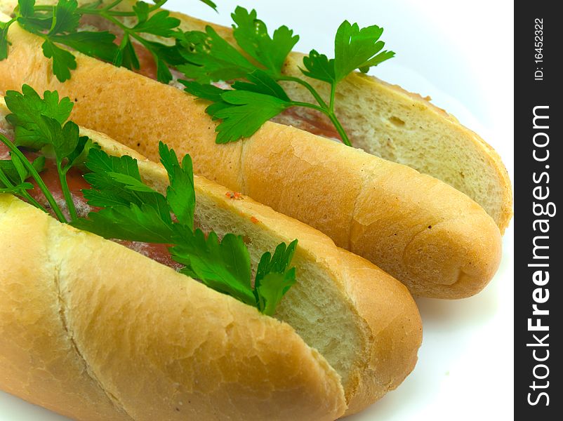 Two beautiful appetizing hot dogs decorated with parsley greens. Two beautiful appetizing hot dogs decorated with parsley greens