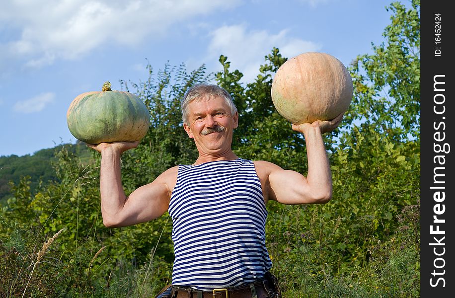 The man with two pumpkins in his hands. The man with two pumpkins in his hands.