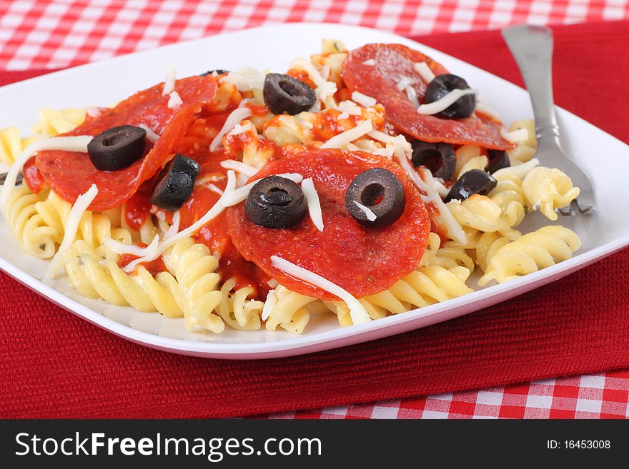 Rotini pasta with pizza sauce, pepperoni, and black olives. Rotini pasta with pizza sauce, pepperoni, and black olives