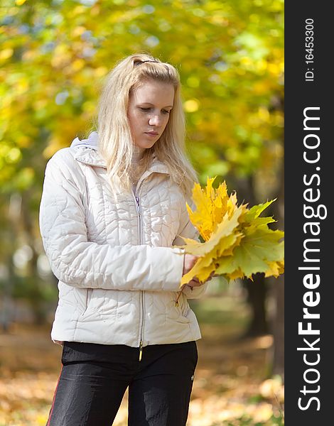 Girl Is Standing And Holding A Yellow Maple Leaves