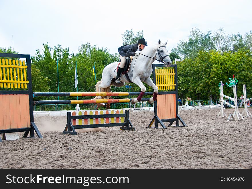 Jockey jumps over a hurdle at the competition