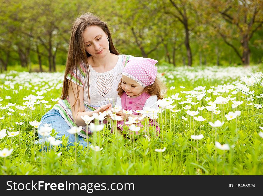 Happy mother and daughter among white flowers