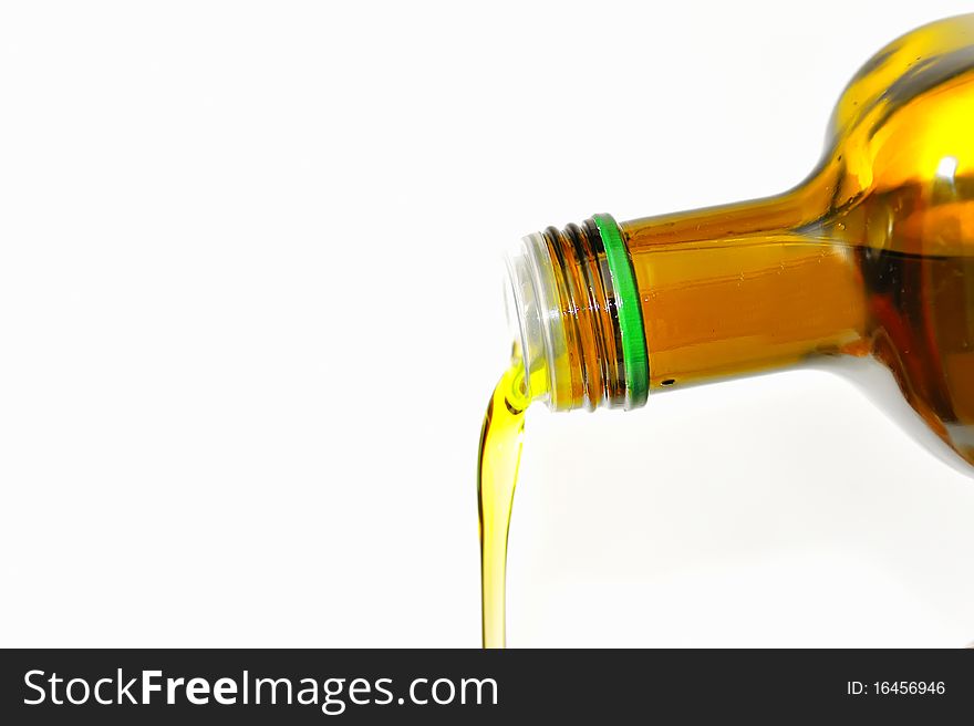 Olive Oil pouring from a bottle isolated on white