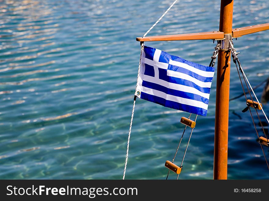 The Flag of Greece on a boat in the harbor of a Greek island. The Flag of Greece on a boat in the harbor of a Greek island.