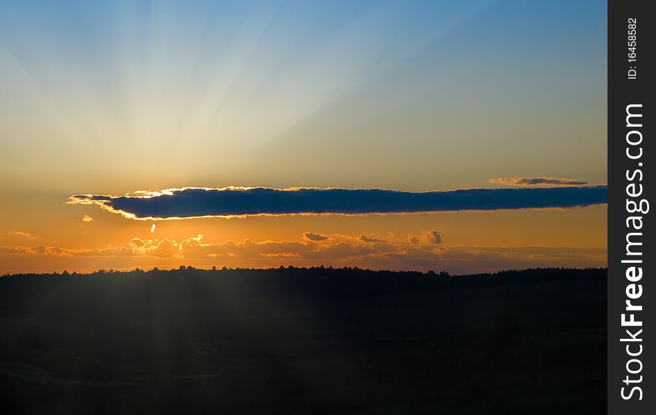 Sunset with dark cloud over meadow landscape. Sunset with dark cloud over meadow landscape