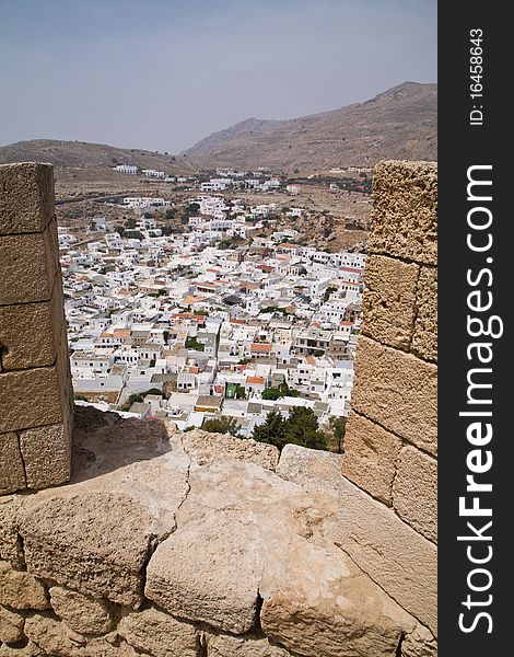 View on Lindos Town from the ancient Acropolis of Lindos, on the Greek island of Rhodes. View on Lindos Town from the ancient Acropolis of Lindos, on the Greek island of Rhodes.