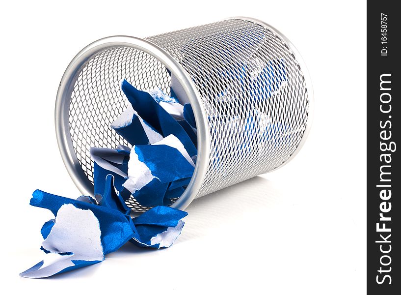 A silver mesh waste paper bin with blue paper spilling from it. A silver mesh waste paper bin with blue paper spilling from it