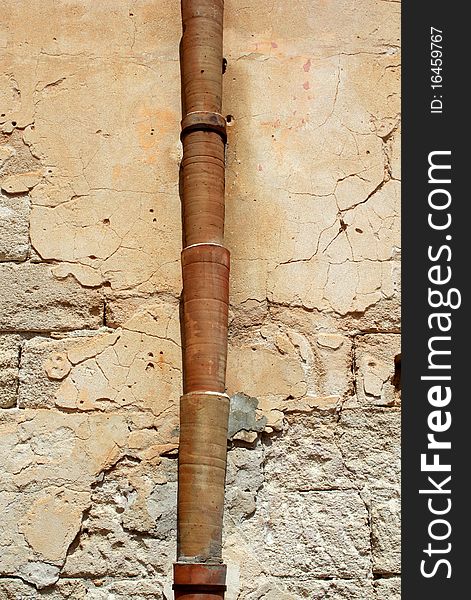 Ceramic drain pipe set against a plastered wall in Sicily. Ceramic drain pipe set against a plastered wall in Sicily