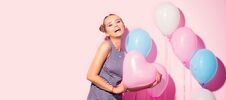 Beauty Girl With Colorful Air Balloons Laughing Over Pink Background. Beautiful Happy Young Woman On Birthday Holiday Party Stock Images