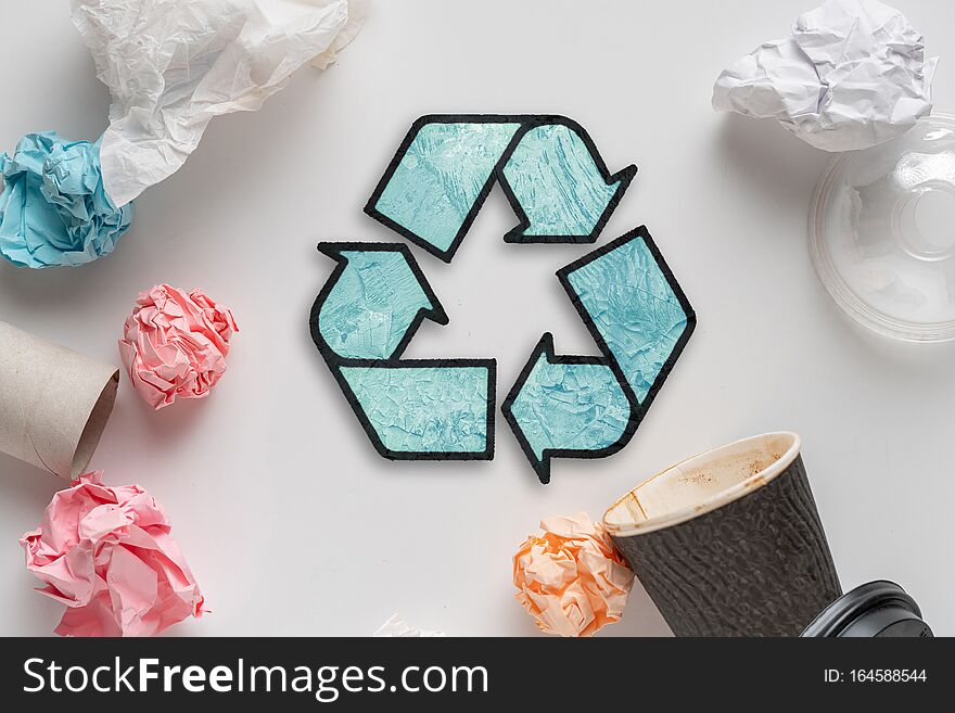 symbol or icon of recycling, top view flat lay with some garbage s