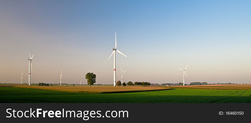 Wind turbines standing in ready to harvest fields. Wind turbines standing in ready to harvest fields