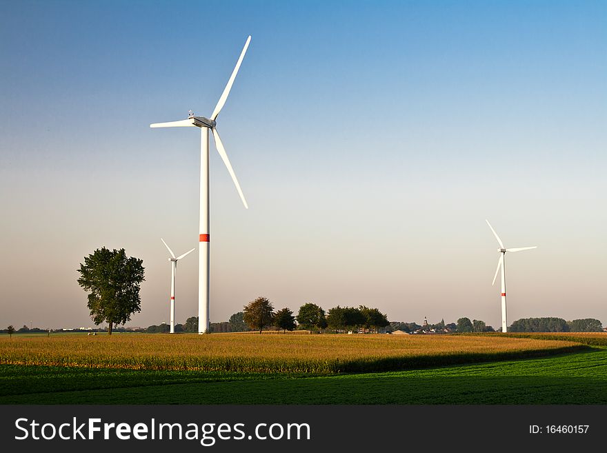 Wind turbines standing in ready to harvest fields. Wind turbines standing in ready to harvest fields