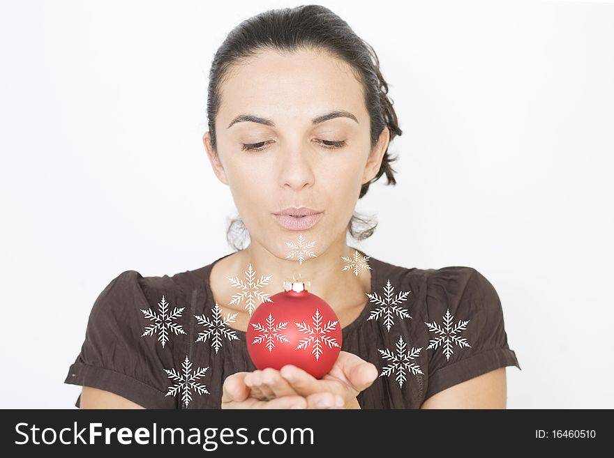 X-mas woman blowing on a red glass beads on Christmas. X-mas woman blowing on a red glass beads on Christmas