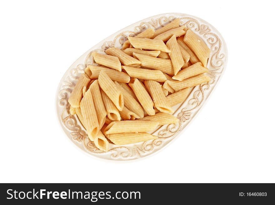 Heap of spelt pasta on plate isolated on white