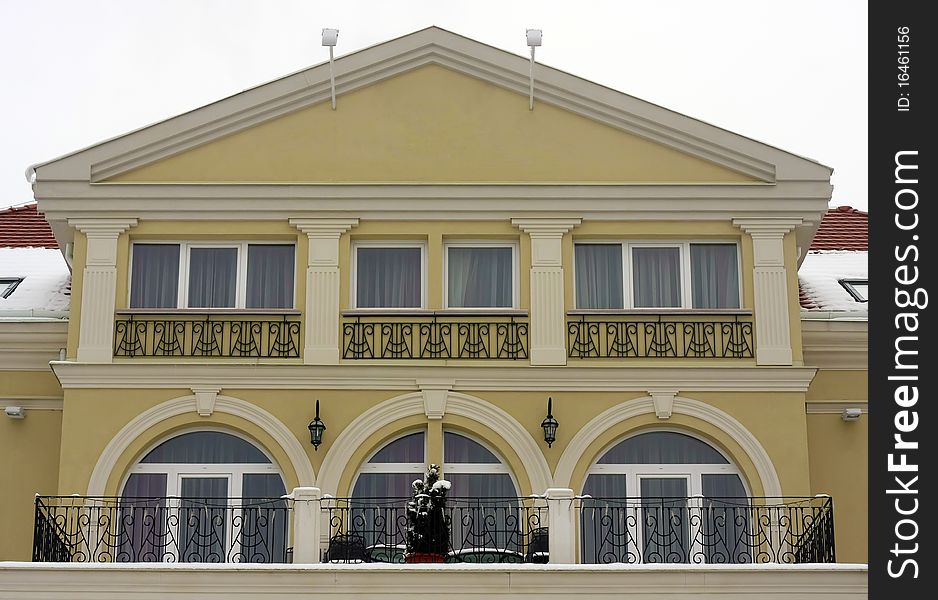 Luxury, renovated villa's frontage. Yellow wall with white ornament and black wrought iron banister. Luxury, renovated villa's frontage. Yellow wall with white ornament and black wrought iron banister.