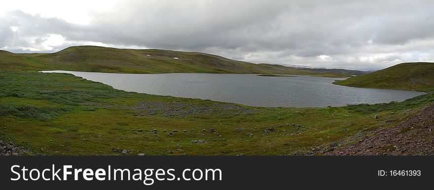 Wild lanscape of Finnmark in the border of Porsangen fjord, havy clouds are very close to nordic tundra