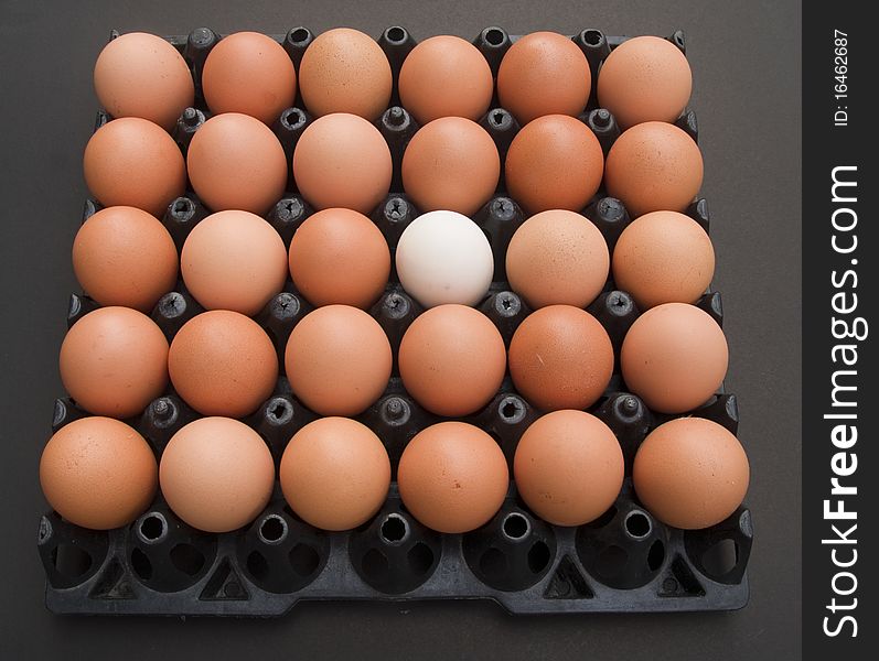 White egg and brown egg on black plastic
