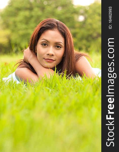 Romantic portrait of young lady lying on grass. Romantic portrait of young lady lying on grass