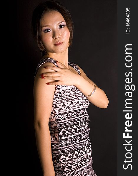 Cute Chinese teenager wearing short skirt, young and fashionable. Pretty Asian female model with black background. Cute Chinese teenager wearing short skirt, young and fashionable. Pretty Asian female model with black background.