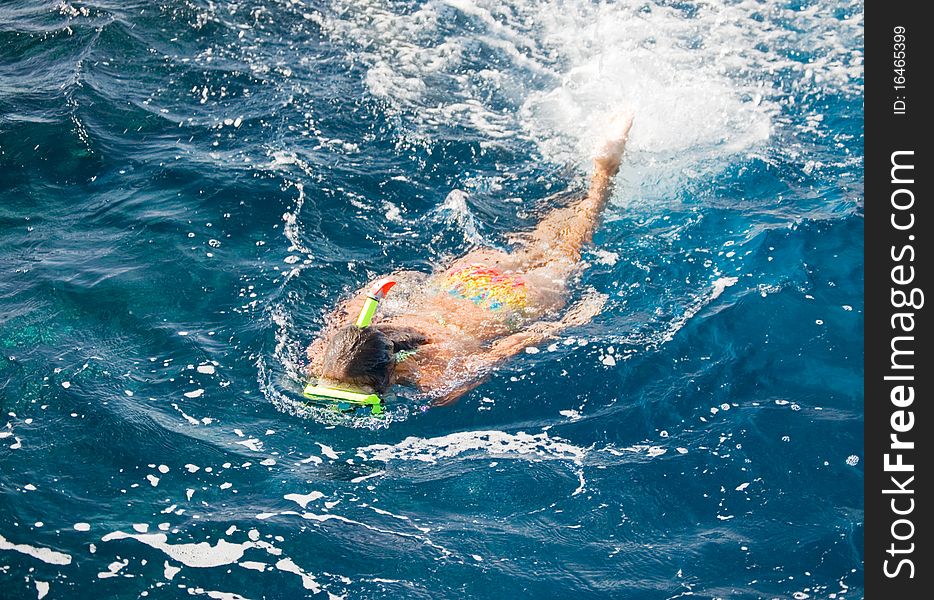 Girl floats in the sea in a mask