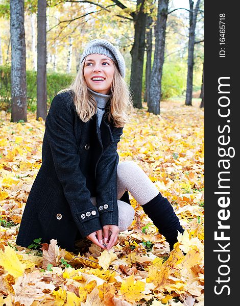 Beautiful young woman in autumn foliage