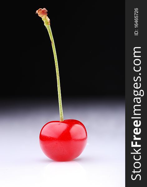 Two cherries against dark background